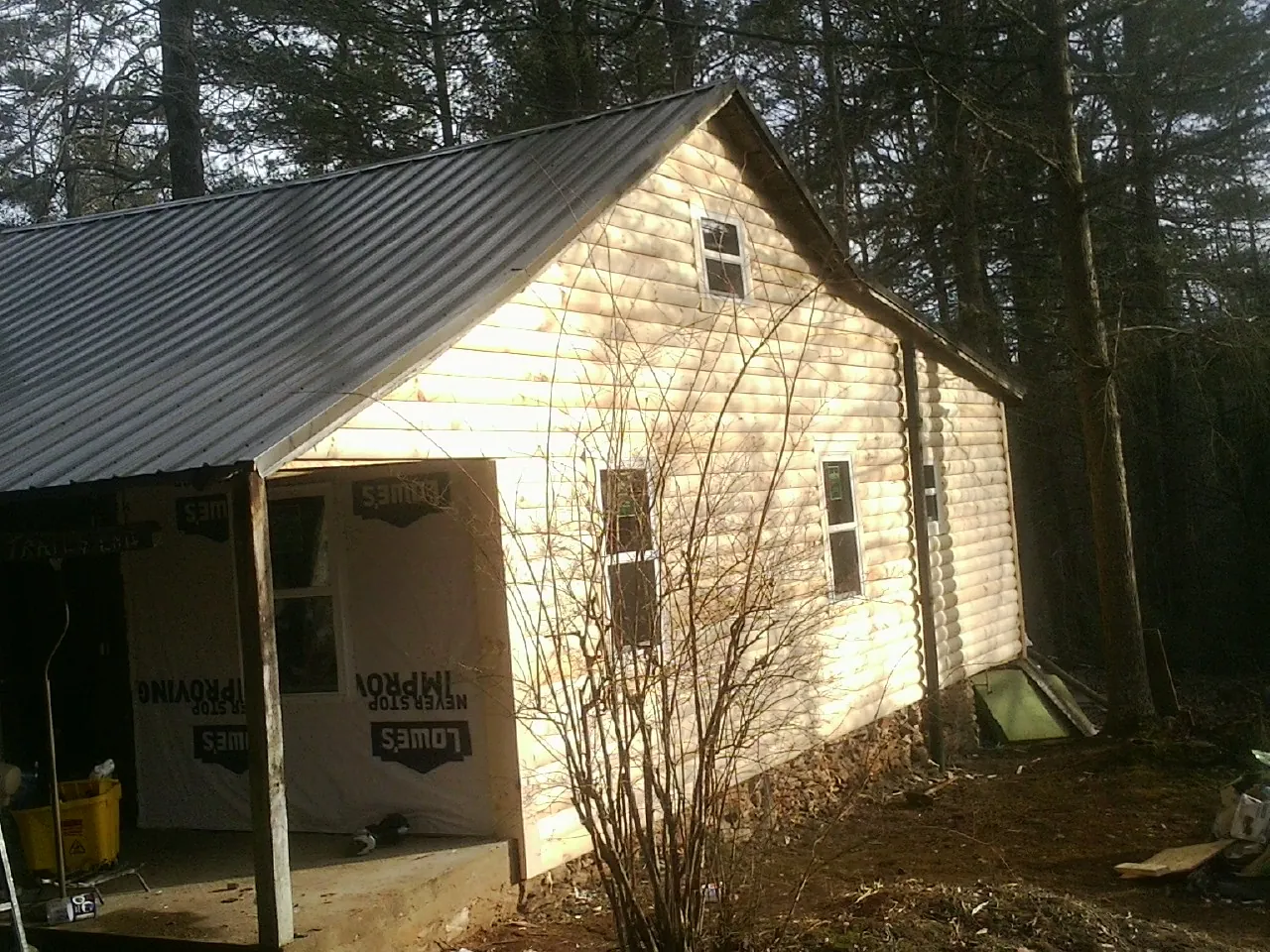 Log siding gable end under a dark metal roof edge in Tuckerton