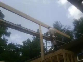 Carpenter setting a ridge beam over a new addition frame — Ice Dam Removal by Roofing Brothers in Tuckerton
