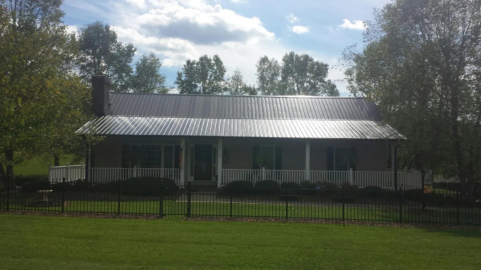 Gray metal roof on a brick ranch with a full width front porch — Gutter Guard Installation work by our crew in Tuckerton