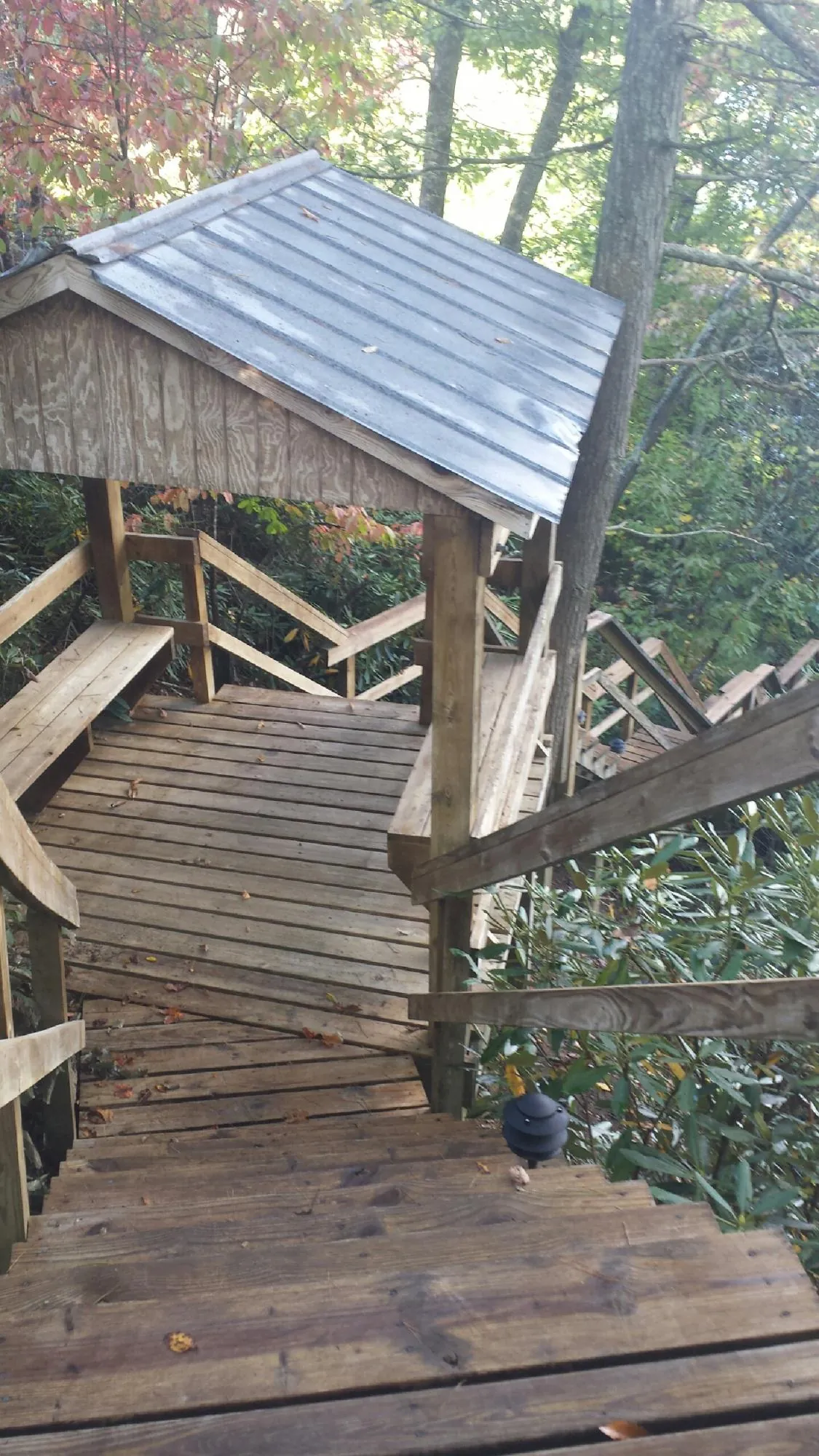 Metal roofed shelter over wooden steps on a wooded walkway — Skylight Repair & Installation work by our crew in Tuckerton