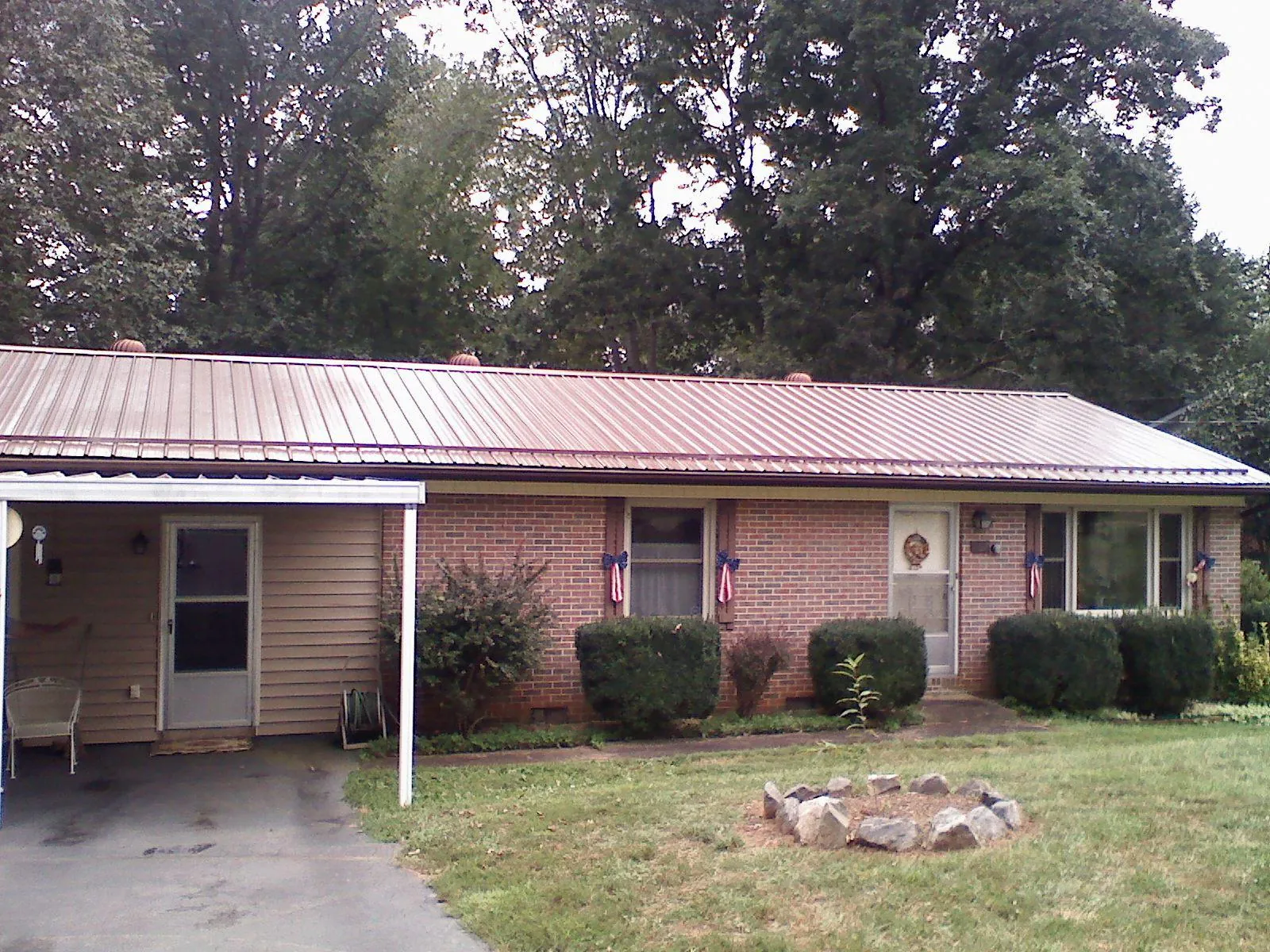 Bronze metal roof and carport on a brick ranch home — Roof Repair work by our crew in Tuckerton